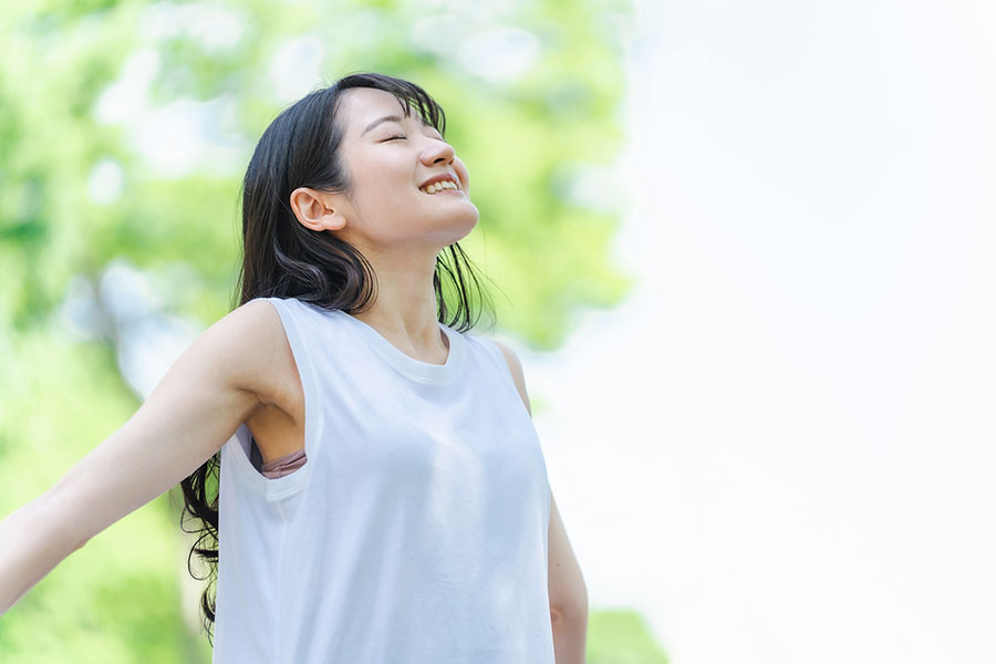 新緑の中で深呼吸する女性